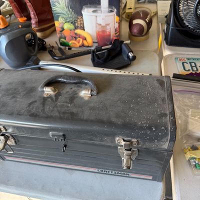 Vintage Craftsman metal toolbox with a black textured finish and metal latches, shown alongside a boxed Vitamin Bar juicer and other...