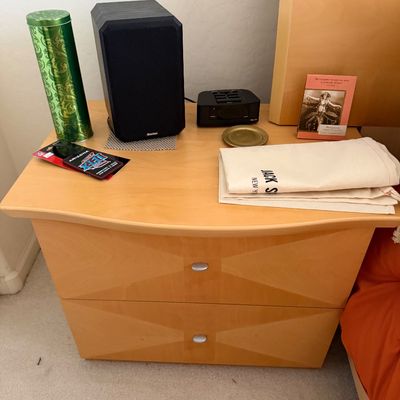 Sale Photo Thumbnail #159: Contemporary light wood two-drawer nightstand with a curved front edge and geometric veneer detailing, holding a Boston Acoustics speaker and other small items.