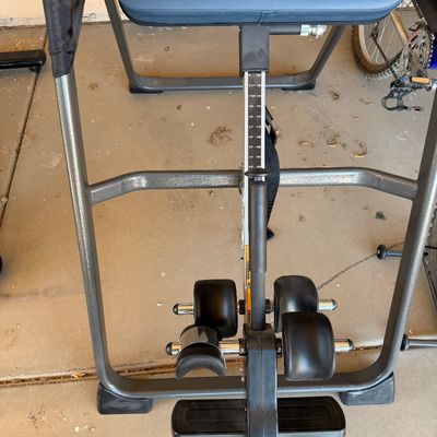 Sale Photo Thumbnail #228: Teeter inversion table featuring a blue padded backrest, adjustable height settings, and secure ankle locks, shown in good used condition.