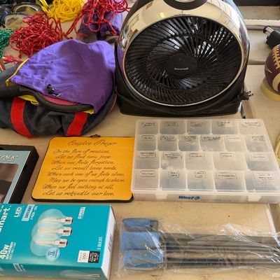 Sale Photo Thumbnail #105: Assorted household and utility items, including a Honeywell table fan, a West Marine hardware organizer box, a box of LED light bulbs, and a decorative plaque with a "Couple's Prayer."