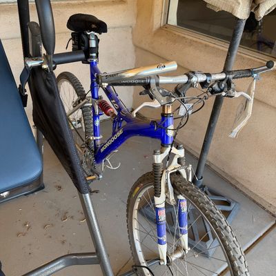Sale Photo Thumbnail #229: Mongoose full-suspension mountain bike in blue, featuring a RockShox front fork and rear shock absorber.