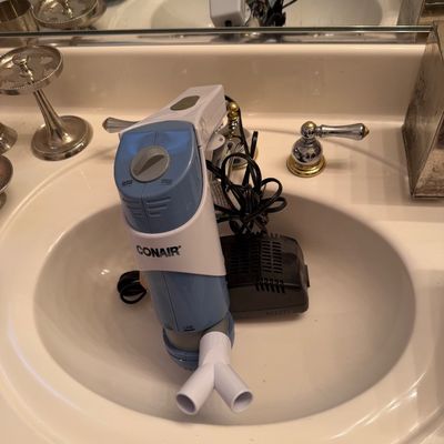 Sale Photo Thumbnail #165: Conair blue and white electric hair styling tool with power adapter, resting in a bathroom sink.