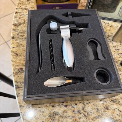 Sale Photo Thumbnail #196: Modern rabbit-style wine opener set in a custom foam-lined storage box, including a foil cutter, replacement worm, and pourer.