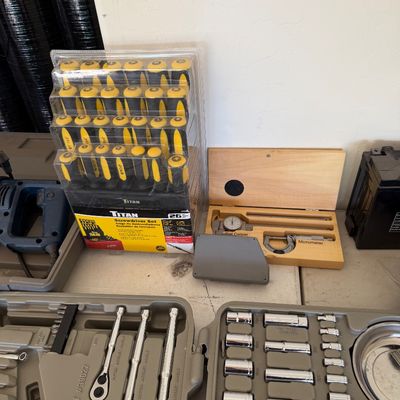 Assorted hand tools and precision instruments, including a Titan 26-piece screwdriver set in original packaging, a boxed dial caliper and...