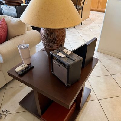 Sale Photo Thumbnail #274: Contemporary dark wood end table featuring a Yamaha guitar amplifier, a large ceramic table lamp with a textured base, and a wooden box on the lower shelf.