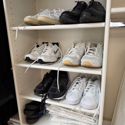 Sale Photo Thumbnail #126: Assorted men's athletic shoes and casual footwear, including Nike and Reebok sneakers, displayed on white closet shelving.