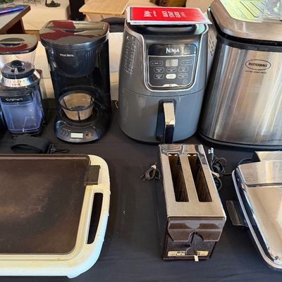 Sale Photo Thumbnail #258: Collection of small kitchen appliances including a Ninja air fryer, Butterball electric turkey fryer, West Bend coffee maker, Cuisinart coffee grinder, electric griddle, and a vintage two-slice toaster.