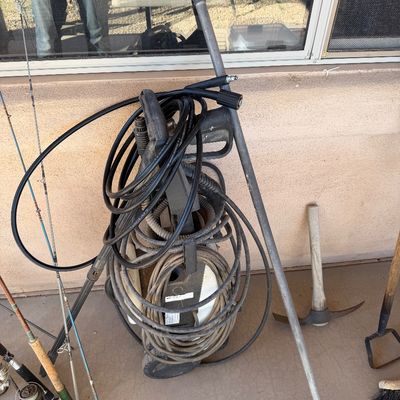 Sale Photo Thumbnail #236: Used electric pressure washer with coiled hoses and spray wand, shown alongside fishing rods and outdoor hand tools.