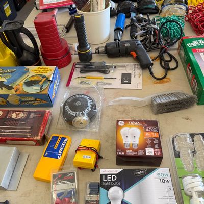 Sale Photo Thumbnail #103: Assortment of household tools and hardware, including a Black & Decker power drill, LED light bulbs, a Zircon stud finder, paintbrushes, and various electrical accessories.