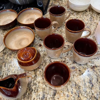 Sale Photo Thumbnail #200: Pfaltzgraff "Naturewood" or similar style stoneware collection, featuring six mugs, three bowls, a lidded sugar bowl, and a creamer pitcher in a brown and tan glaze.
