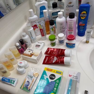 Sale Photo Thumbnail #130: Assortment of personal care and hygiene products, including Dove body wash, Colgate toothpaste, Listerine mouthwash, and various toiletries arranged on a bathroom counter.
