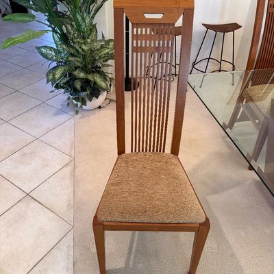 Sale Photo Thumbnail #299: Contemporary high-back dining chair featuring a wooden frame with vertical slats and a textured beige upholstered seat.