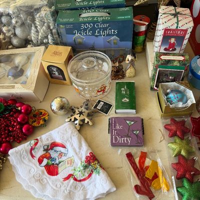 Assortment of vintage and modern Christmas decorations, including boxed icicle lights, glass ornaments, a Santa tree skirt, and novelty...