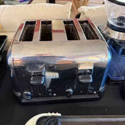 Sale Photo Thumbnail #259: Four-slice chrome toaster with black plastic base and controls, showing some light wear from use.