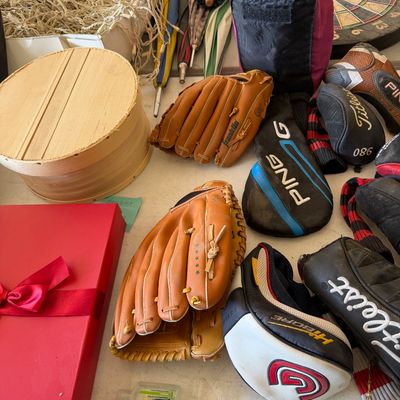 Assortment of sporting goods and household items, including leather baseball gloves, golf club headcovers from Ping and Titleist,...