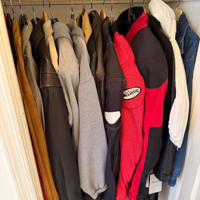 Sale Photo Thumbnail #187: Assorted men's outerwear hanging in a closet, including a red and black Joe Rocket Ballistic motorcycle jacket, leather jackets, and hoodies.
