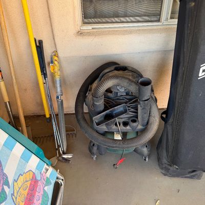 Sale Photo Thumbnail #250: Craftsman wet/dry shop vacuum with hose and attachments, shown alongside golf clubs and outdoor gear.