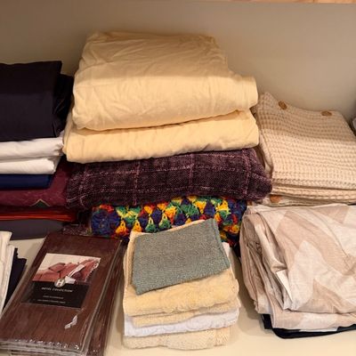 Sale Photo Thumbnail #176: Assorted household linens including folded sheets, blankets, towels, and a packaged Hotel Collection Euro pillow sham.