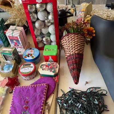 Assortment of holiday decorations, including a large box of silver and white ornaments, decorative tins, a woven cornucopia, and string...