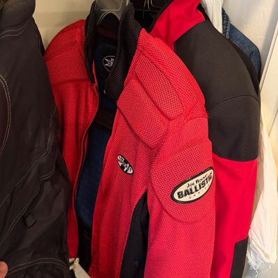 Sale Photo Thumbnail #179: Joe Rocket Ballistic Series red and black mesh motorcycle jacket, hanging in a closet alongside other outerwear.