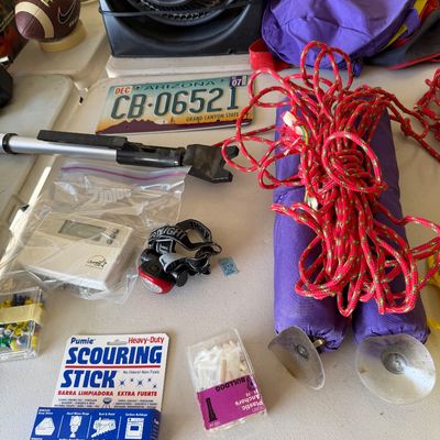 Assorted household and outdoor items, including a 2007 Arizona license plate, a headlamp, a scouring stick, plastic anchors, and a coiled...