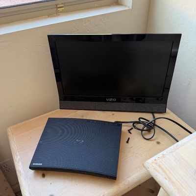 Sale Photo Thumbnail #186: Vizio flat-screen television paired with a Samsung Blu-ray player, displayed on a light wood side table.