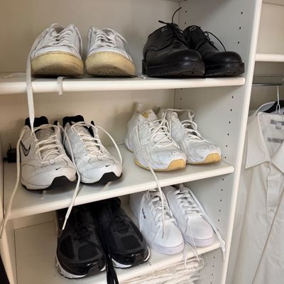 Sale Photo Thumbnail #112: Assorted men's and women's athletic sneakers and dress shoes, including Nike and Reebok brands, displayed on white closet shelving.