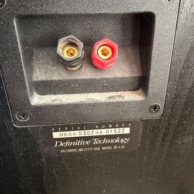 Sale Photo Thumbnail #314: Rear terminal panel of a Definitive Technology BP-1.2X speaker, showing the gold-plated binding posts and serial number label.