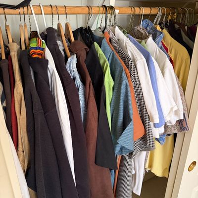 Sale Photo Thumbnail #152: Assorted men's casual shirts, jackets, and sweaters hanging in a closet, featuring a mix of colors, patterns, and styles.