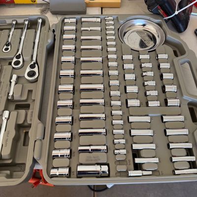 Comprehensive socket and ratchet wrench set in a gray molded plastic carrying case, appearing complete and in good condition.