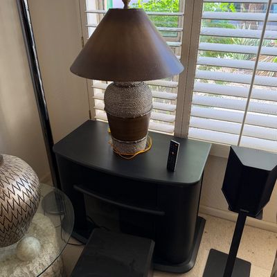 Sale Photo Thumbnail #311: Contemporary table lamp with a rope-wrapped ceramic base and a brown conical shade, displayed on a black media console.