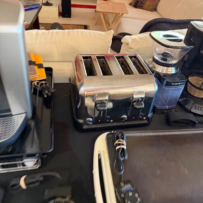 Sale Photo Thumbnail #264: Assorted kitchen appliances including a chrome four-slice toaster, a Cuisinart coffee grinder, and an electric griddle.