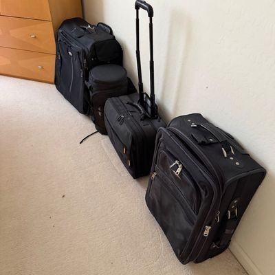 Sale Photo Thumbnail #161: Collection of black soft-sided luggage, including rolling suitcases and a duffel bag, showing light wear.