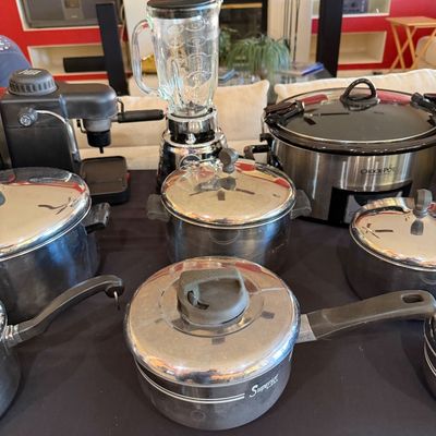 Sale Photo Thumbnail #265: Assorted kitchen appliances and cookware, including an Osterizer blender, a Crock-Pot slow cooker, an espresso machine, and several stainless steel pots with lids.