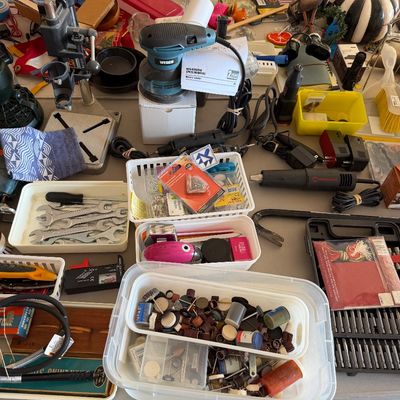Sale Photo Thumbnail #104: Assortment of workshop tools and hardware, including a Wesco rotary sander, a drill press stand, wrenches, and various organizer bins filled with accessories.