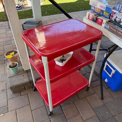 Sale Photo Thumbnail #168: Vintage Cosco-style three-tier rolling utility cart with red painted shelves and white metal legs.