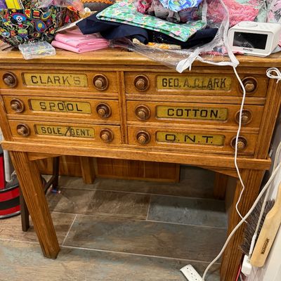 Sale Photo Thumbnail #47: Antique Clark's O.N.T. spool cotton oak cabinet on legs, featuring six drawers with original stenciled labels and wooden knobs.