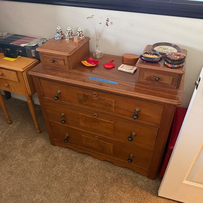 Sale Photo Thumbnail #16: Antique wood dresser featuring three large drawers with drop-pull handles, two small top-mounted glove drawers, and a selection of decorative trinkets and small boxes.