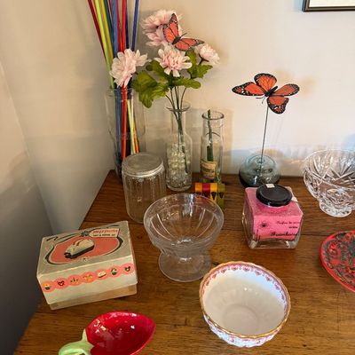 Sale Photo Thumbnail #170: Assorted tabletop decor and glassware, including a vintage Pop-Up Toaster salt and pepper set in its original box, a strawberry-shaped dish, and various decorative glass vases.