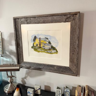 Sale Photo Thumbnail #199: Framed watercolor painting of a yellow house on a hill, presented in a rustic weathered wood frame with a wide white mat.