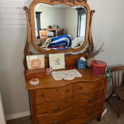 Sale Photo Thumbnail #28: Antique quarter-sawn oak serpentine dresser featuring a matching swivel mirror with ornate carved detailing.