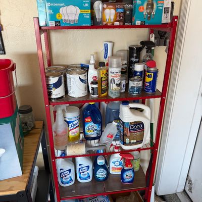 Sale Photo Thumbnail #115: Red metal four-tier shelving unit stocked with household cleaning supplies, paint cans, and various lightbulbs.
