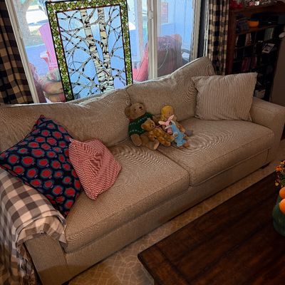 Sale Photo Thumbnail #216: Contemporary three-cushion sofa in a neutral herringbone upholstery, styled with various throw pillows and plush toys.