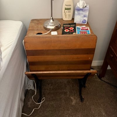 Sale Photo Thumbnail #8: Vintage school desk featuring a wooden top and seat back with cast iron legs, repurposed as a bedside nightstand.
