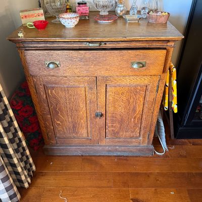 Sale Photo Thumbnail #171: Antique quarter-sawn oak washstand or commode cabinet, featuring a single wide drawer with brass cup pulls above a two-door lower cabinet.
