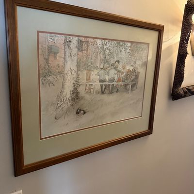 Sale Photo Thumbnail #7: Framed Carl Larsson print depicting a group of children seated at an outdoor table, presented in a wooden frame with double matting.