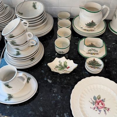 Sale Photo Thumbnail #134: Assorted holiday-themed ceramic tableware, including a Spode Christmas Tree pitcher, pinecone-motif cups and plates, and a floral-patterned plate.