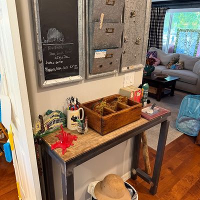 Sale Photo Thumbnail #114: Industrial-style console table with a wood top and metal frame, paired with a wall-mounted galvanized metal organizer set featuring a chalkboard and mail slots.