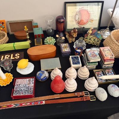 Sale Photo Thumbnail #19: Eclectic assortment of tabletop decor, including miniature US Capitol building models, playing cards, a framed anatomical eye diagram, wooden boxes, and beaded leather belts.