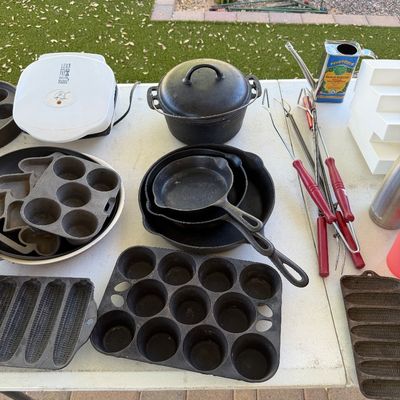 Sale Photo Thumbnail #152: Assortment of vintage cast iron cookware, including a Dutch oven, skillets, muffin tins, and cornstick pans, displayed alongside a George Foreman grill and grilling utensils.